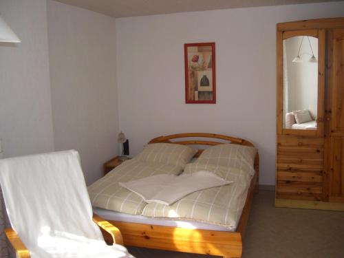 a small bedroom with a bed and a mirror at Gästehaus Jeremias in Königstein an der Elbe