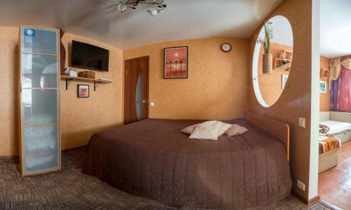 1 dormitorio con cama y espejo redondo en Apartment na Prospekte Lenina, en Dzerzhinsk