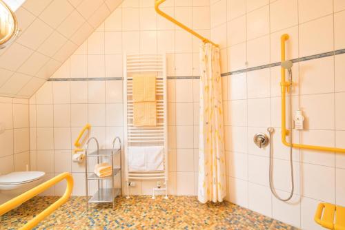a bathroom with a shower and a toilet at Hotel Altes Zollhaus in Horumersiel