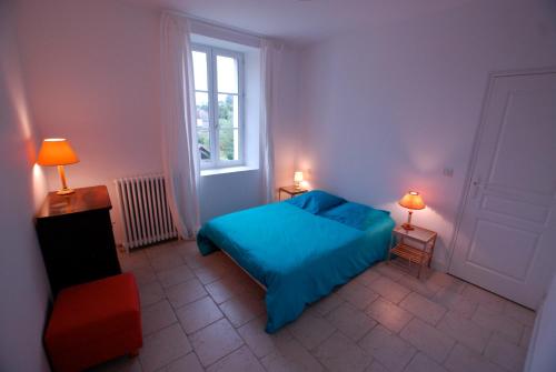 ein Schlafzimmer mit einem blauen Bett und einem Fenster in der Unterkunft Chambres d'Hôtes Les Bords du Cher in Saint-Aignan