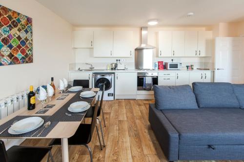 a kitchen and living room with a table and a couch at Castle Point Apartments Southampton Premier Lodge in Southampton