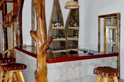 a bar in a room with some bottles of wine at Kivu Paradis Resort in Nyamyumba