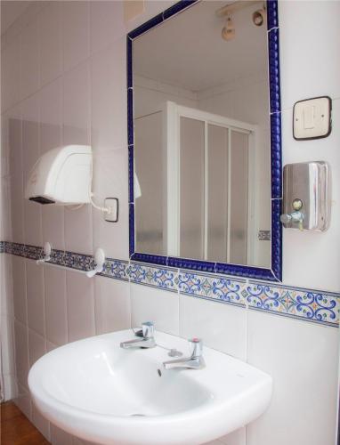 a bathroom with a sink and a mirror at Hostal París in La Línea de la Concepción