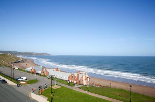 a view of a beach with a house and the ocean at Riviera Guesthouse in Whitby