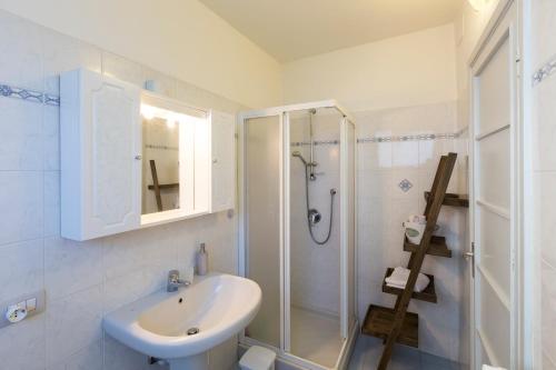 a white bathroom with a sink and a shower at Rio Molino in Stresa