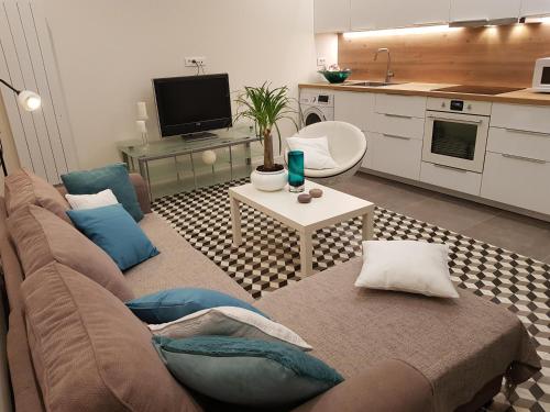 a living room with a couch and a kitchen at 35m2 - 10 min de CDG in Le Thillay