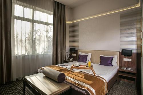 a hotel room with a bed and a window at Grand Hotel Glorius Makó in Makó