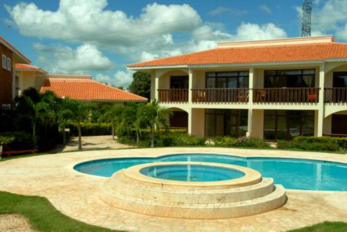 a house with a swimming pool in front of a house at Green Paradise in Juan Dolio