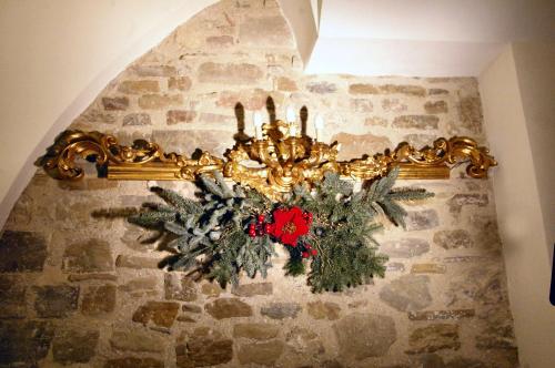 a christmas wreath on a wall with a chandelier at San Francesco Resort in Agropoli