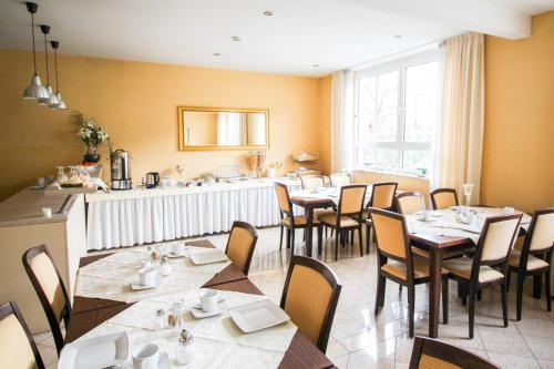 um restaurante com mesas e cadeiras num quarto em Hotel Ferchenhof em Munique