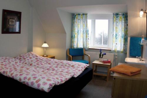 a bedroom with a bed and a sink and a window at Hotel Lolland in Nørreballe