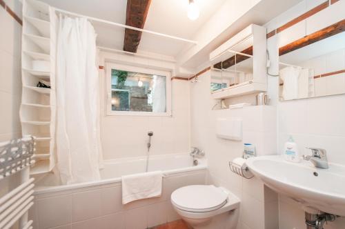 ハンブルクにあるAlster City Garden Villaの洗面台とトイレを備えた白いバスルーム