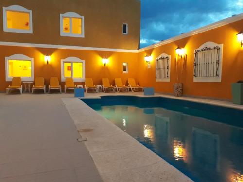 a swimming pool in a house with orange walls at Hotel Colonos in Las Grutas