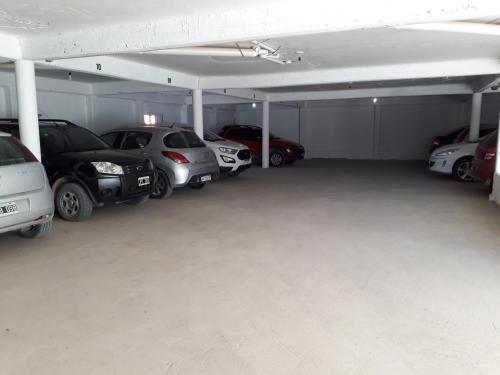 a garage with a bunch of cars parked in it at Hotel Colonos in Las Grutas