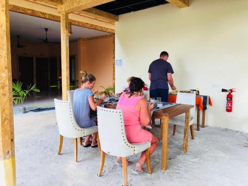 a group of people sitting at a table at Veli Beach Inn in Mathiveri
