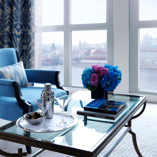 a living room with a glass coffee table with a vase of flowers at Four Seasons Hotel Prague in Prague