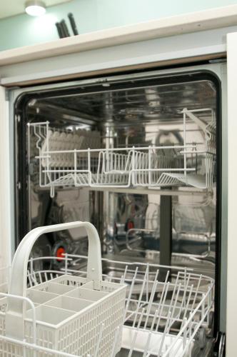 an open dishwasher with white dishes in it at Cleyro Serviced Apartments - Finzels Reach in Bristol