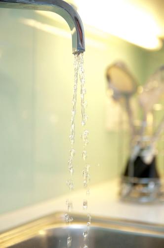 a stream of water pouring from a kitchen sink at Cleyro Serviced Apartments - Finzels Reach in Bristol