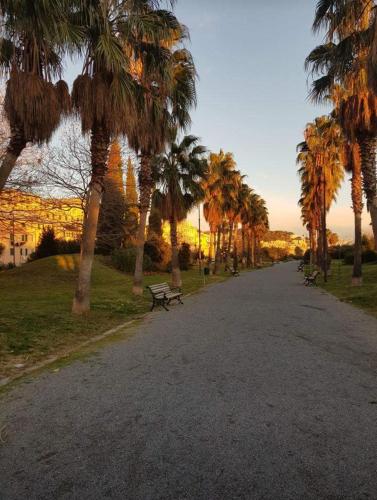 a park with a bench and palm trees on a road at Casa Sole E Luna in Genova