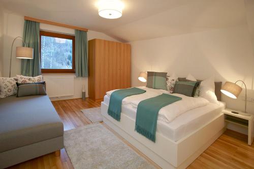 ein Schlafzimmer mit einem großen Bett und einem Sofa in der Unterkunft Ferienhaus Schmidl in Heiligenblut