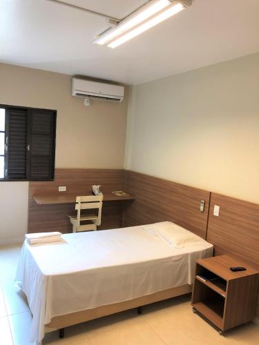 a hospital room with a bed and a desk at Hotel 2 Gauchos in Naviraí
