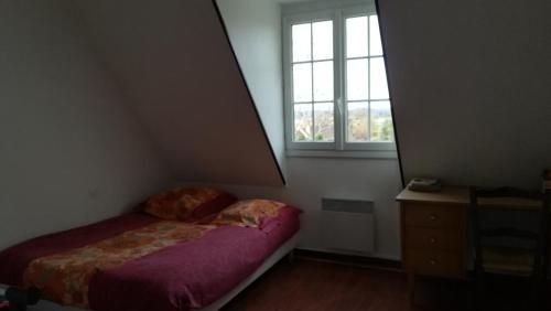 ein kleines Schlafzimmer mit einem Bett und einem Fenster in der Unterkunft Entre mer montagne Béarn et Pays Basque in Orthez