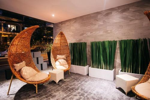 a restaurant with two chairs and green curtains at Searocco Phuket in Patong Beach
