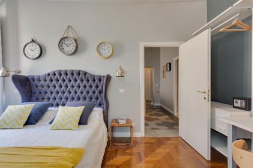 1 dormitorio con 1 cama grande con reloj en la pared en RomExperience Borgo Pio en Roma