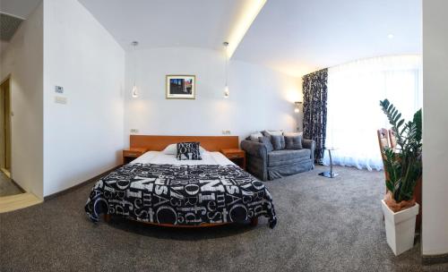 a bedroom with a black and white bed and a chair at Hotel Varazdin in Varaždin