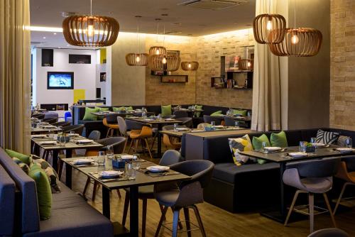 a restaurant with tables and chairs and chandeliers at Novotel Sorocaba in Sorocaba