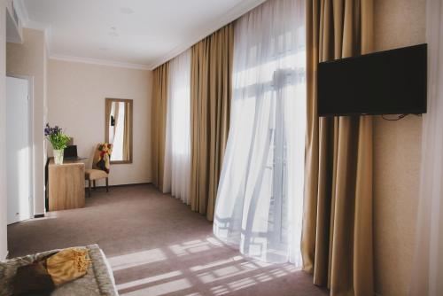 a hotel room hallway with a television and curtains at Hotel Alkor in Truskavets