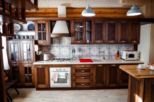 a kitchen with wooden cabinets and a stove top oven at Provintsia in Migovo