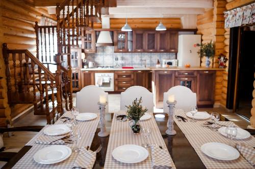 a dining room with a table with white plates and candles at Provintsia in Migovo