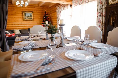 a dining room table with plates and wine glasses at Provintsia in Migovo