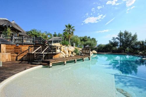 a swimming pool with benches in a resort at Lecci e Murta in Propriano
