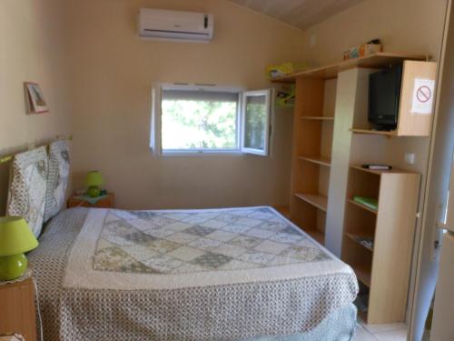 um quarto com uma cama e uma janela em La villa Sam em Vidauban