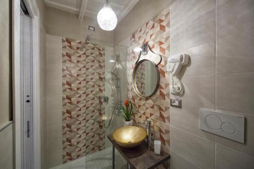 uma casa de banho com um lavatório dourado e um chuveiro em La Rocca Suite em Viterbo