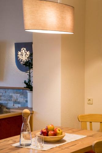 a bowl of fruit on a wooden table with a light at Haus Sonnleit in Kössen