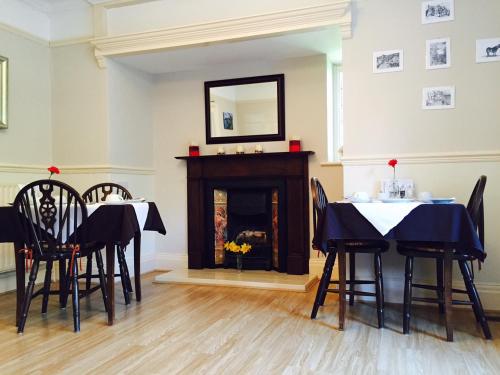 une salle à manger avec une table et des chaises et une cheminée dans l'établissement Longmead House, à Lynton