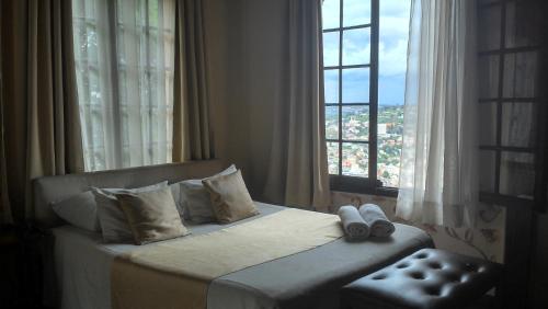 a bedroom with a bed with a large window at Relais De La Haute Ville Tana in Antananarivo