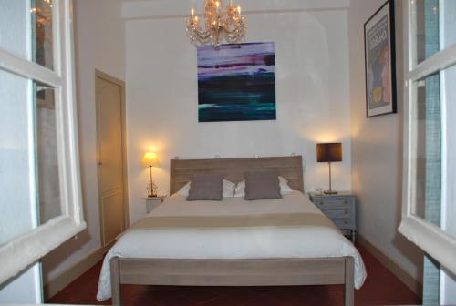 1 dormitorio con cama y lámpara de araña en Apartment Carnot, en Carcassonne