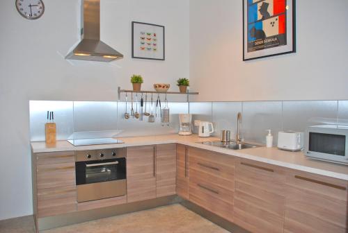 cocina con armarios de madera y horno con fogones en Apartment Carnot en Carcassonne