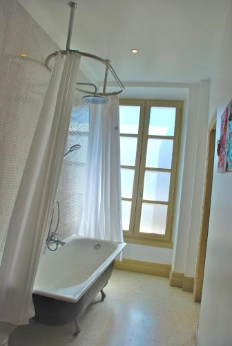 La salle de bains est pourvue d'une baignoire avec rideau de douche. dans l'établissement Apartment Carnot, à Carcassonne