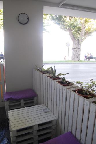 a porch with two stools and a clock on the wall at Maison Audrey in Desenzano del Garda