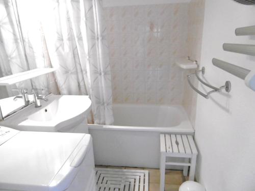 Un baño blanco con bañera y lavabo. en Maisonnette Kristell, en Sarzeau