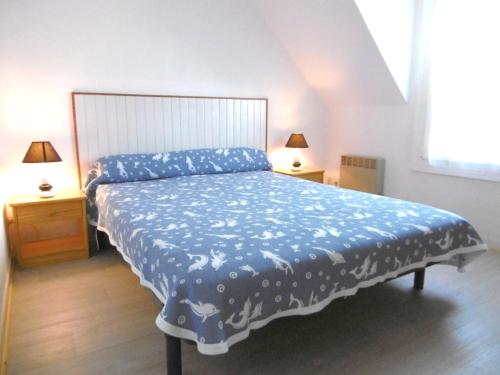 Un dormitorio con una cama grande con un edredón azul. en Maisonnette Kristell, en Sarzeau