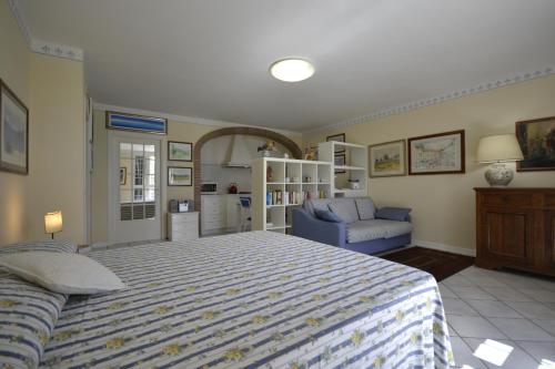 een slaapkamer met een bed, een bank en een stoel bij Appartamento Valentina in Cortona