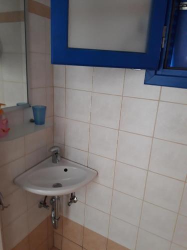 a white sink in a bathroom with a blue window at Vigles in Adamas