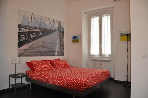 ローマにあるLa Casina di Ludoの赤いベッドと壁に絵画が飾られたベッドルーム1室