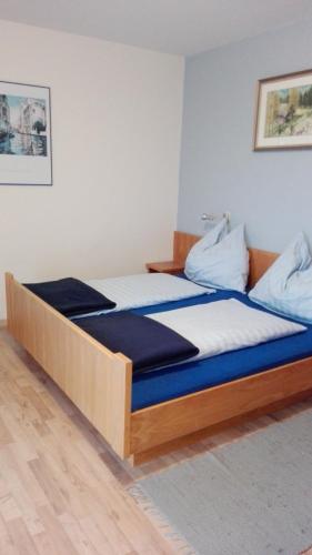 a bedroom with a large bed with blue and white sheets at Pension Barzaunerhof in Fresach